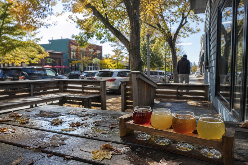 A tasting flight of cider and beer glasses on a patio table