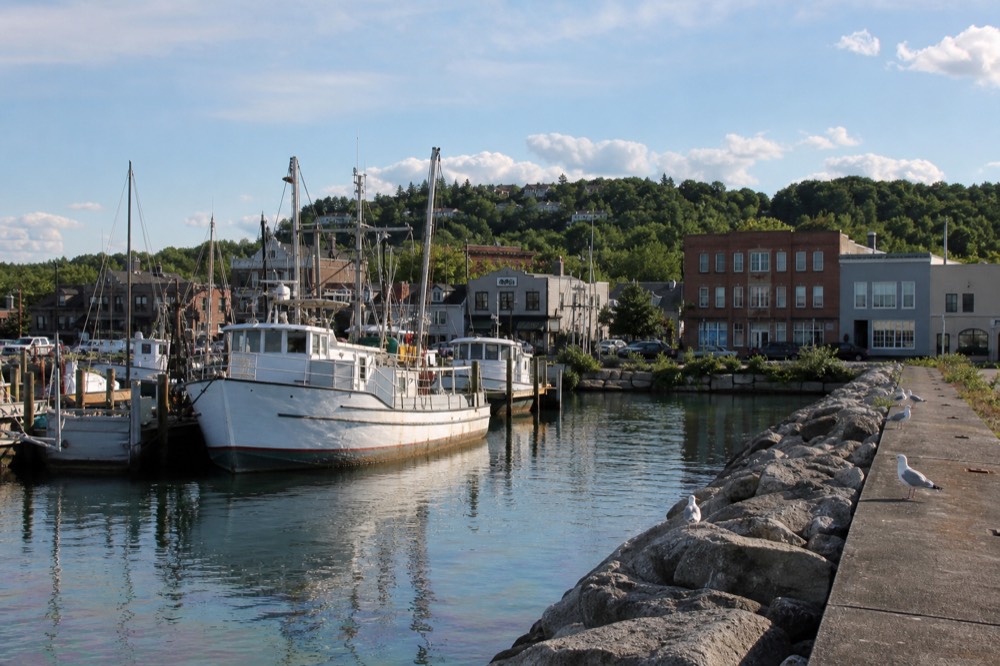 Boats moored in a Lake Michigan harbor with a village main street beyond