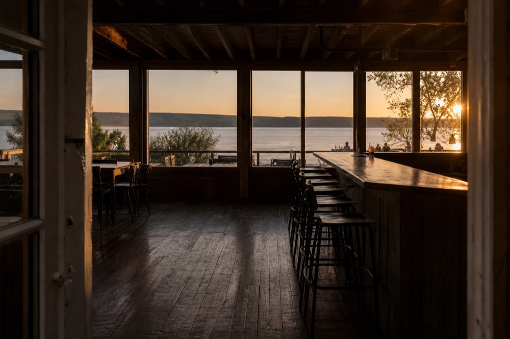 A quiet tasting room bar at golden hour overlooking the bay