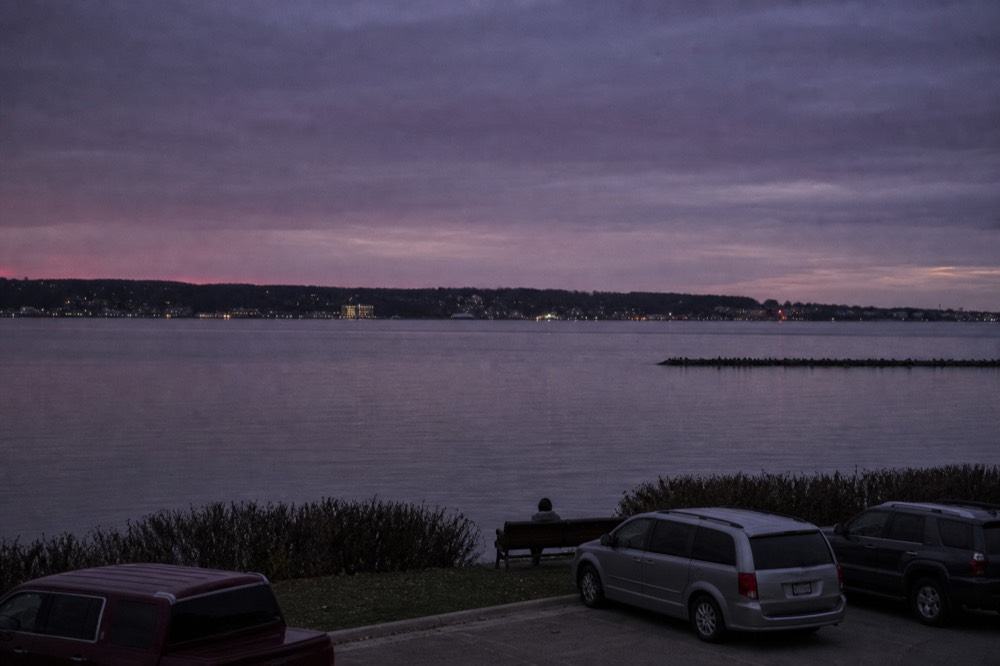 Two northern Michigan wine towns compared across a blue bay at dusk