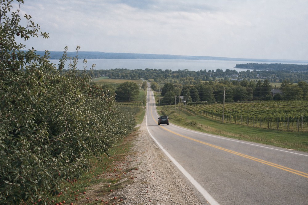 A two-lane rural road running along a peninsula toward open water