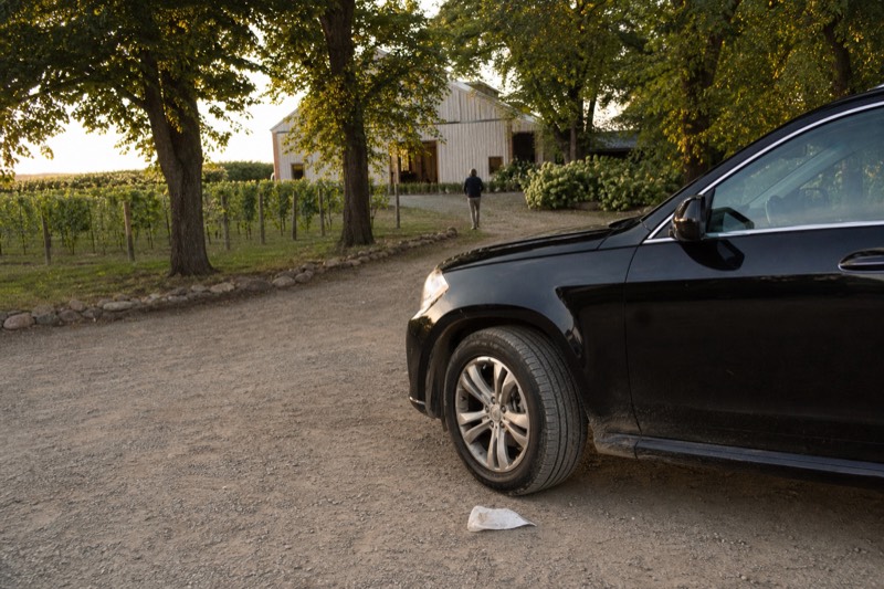 A private vehicle waiting on a quiet winery drive between tasting-room stops