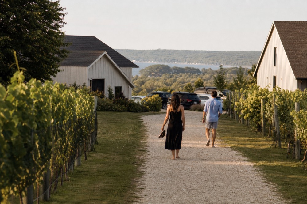 Friends walking a vineyard path between tasting room buildings