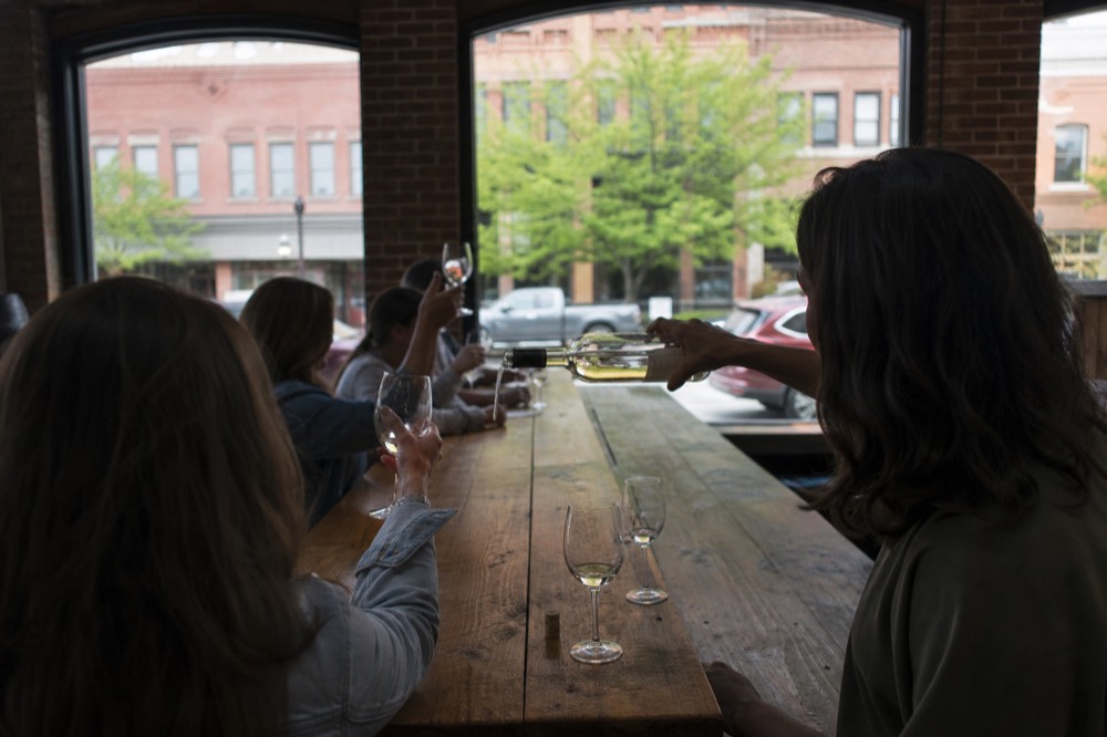 A tasting flight of red wines on a wooden bar top, no text, no logos, no people