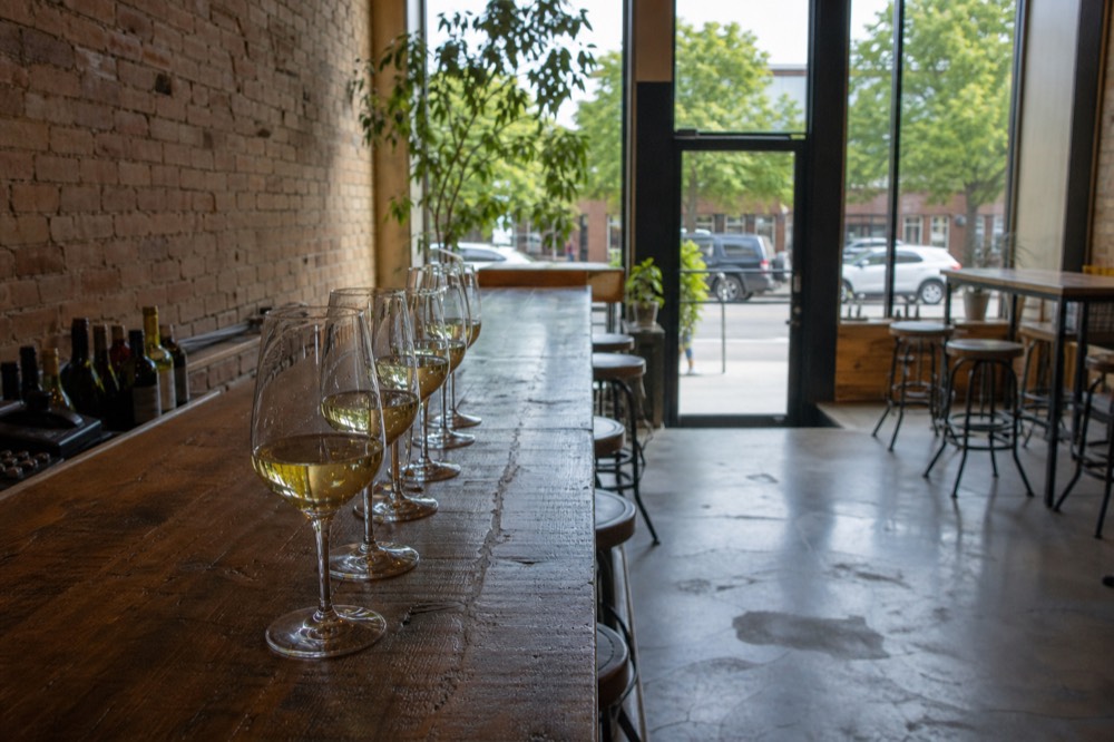 A flight of white wines on a wooden tasting bar