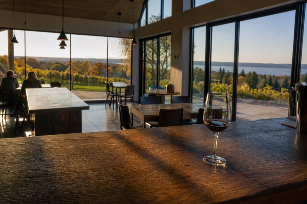 A quiet tasting room interior with long shadows and low sun through tall windows
