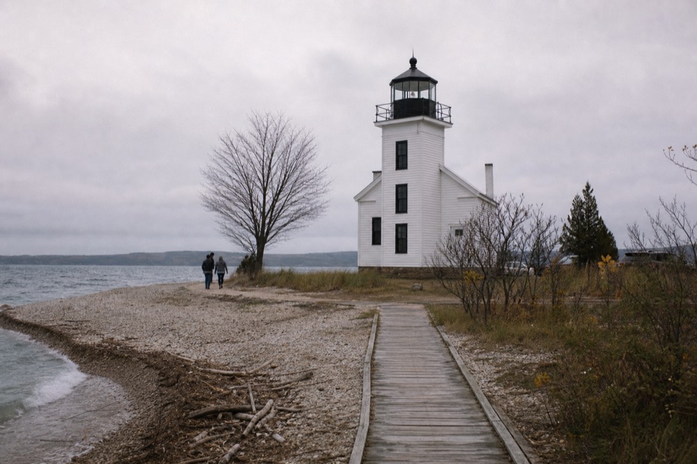 A lighthouse at the tip of a peninsula with open water on both sides