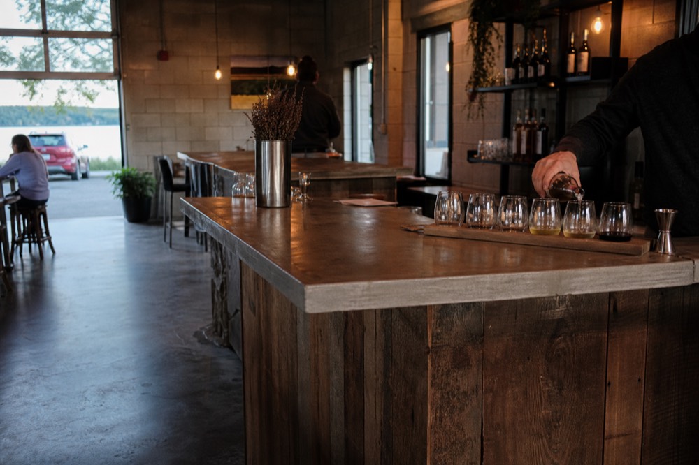 A winery bar with glasses being poured from bottles behind the counter