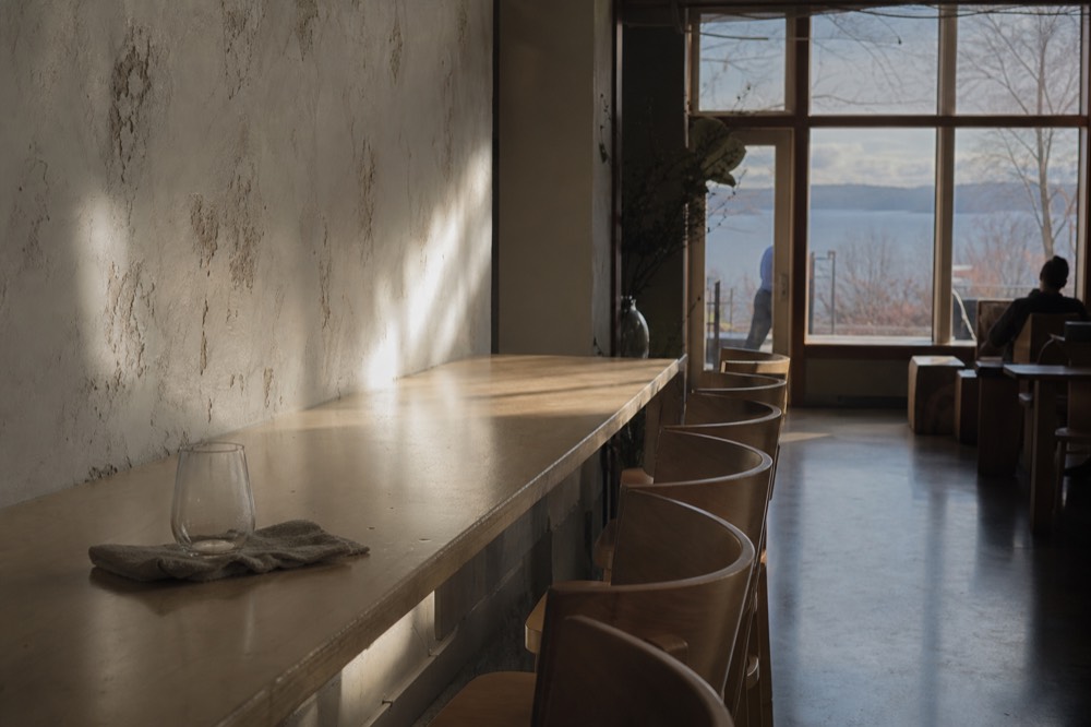 A quiet tasting room in late afternoon light with empty chairs at a bar