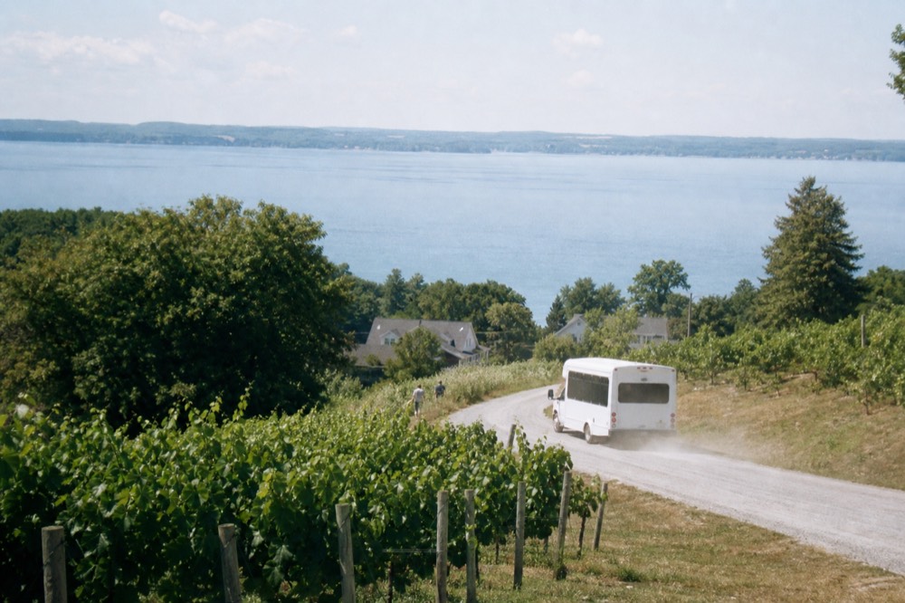 A shuttle bus winding along Center Road between vineyards on Old Mission Peninsula