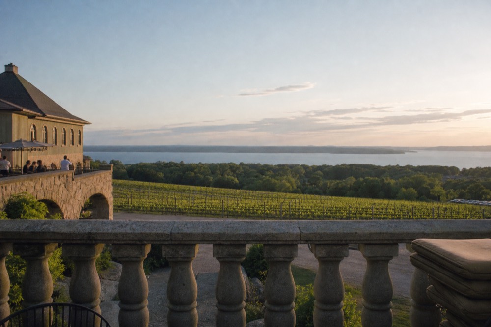 Winery inn terrace above vineyards and bay water